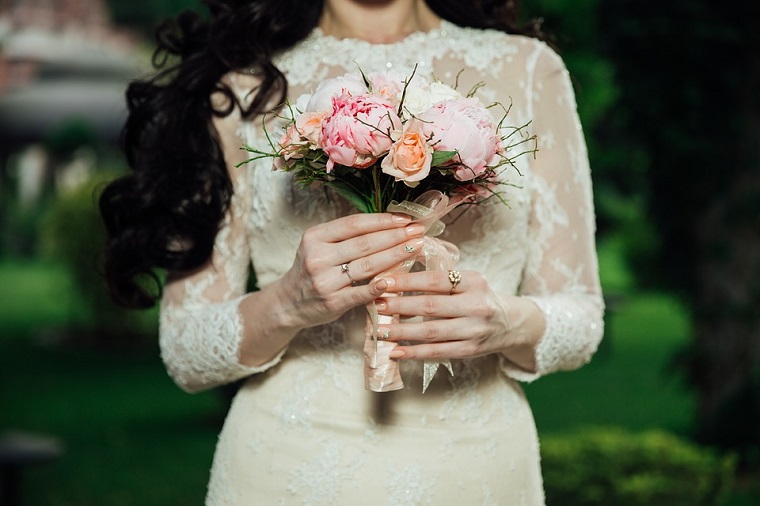 Unghie rosa cipria, manicure a mandorla in abbinamento al bouquet e al vestito della sposa 
