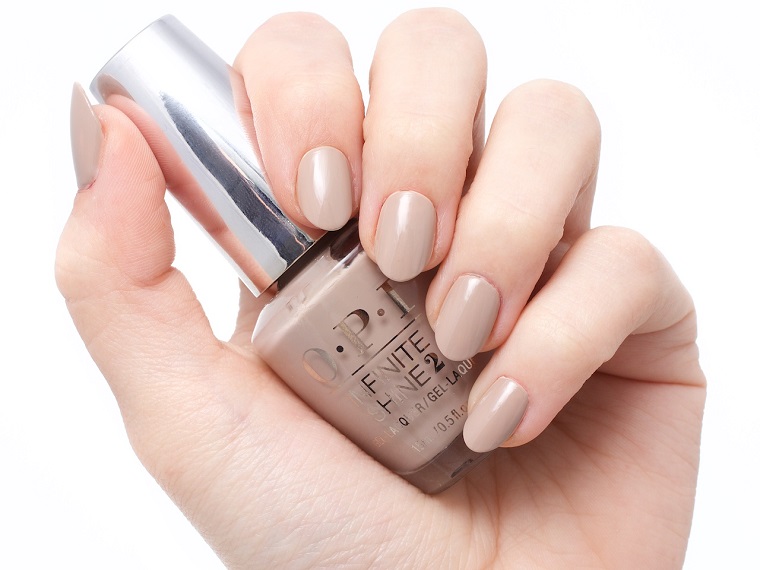 Unghie belle di colore nude, smalto del marchio OPI, mani donna eleganti 