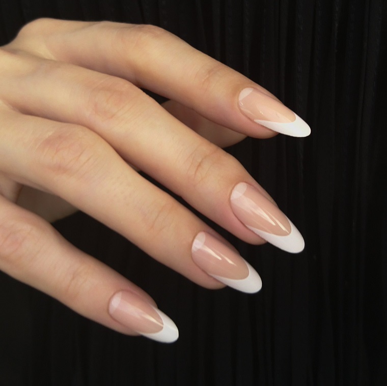 Unghie semplici ed eleganti, stiletto lungo con una manicure alla francese di colore bianco 