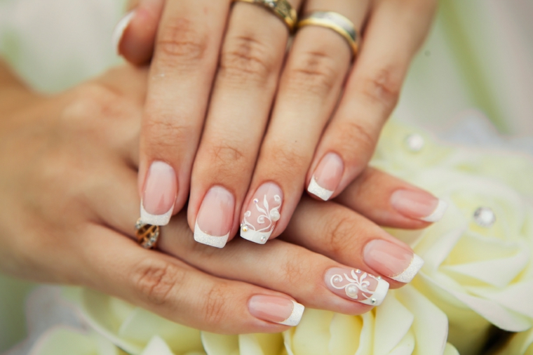 Unghie belle, decorazione della french manicure con fiorellini e piccolo brillantino, mani da sposa 