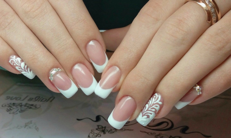 Manicure sposa, french di colore bianco, accent nail con brillantini e disegni motivi floreali 