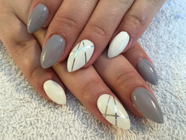 Nail art unghie a punta di colore grigio chiaro e bianco, decorazione di color argento con strisce adesive 