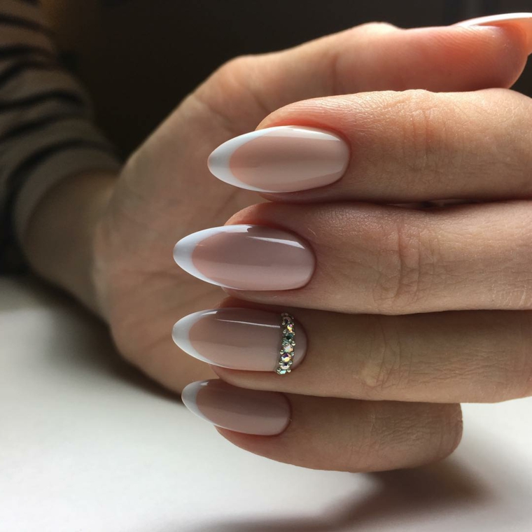Idea decorazione unghie con una french manicure di color pelle e bianco, accent nail con brillantini sul dito anulare 