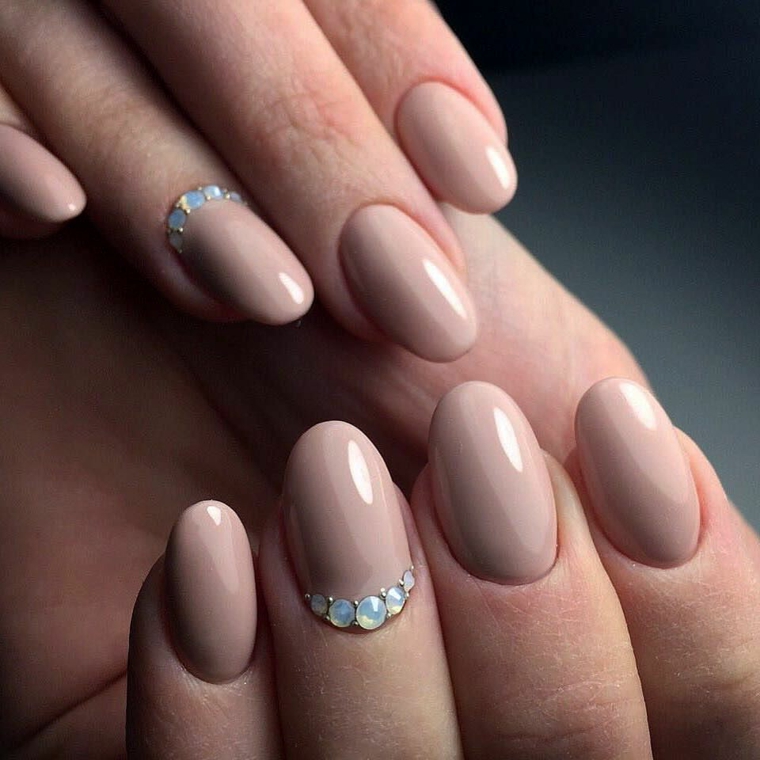 Unghie a mandorla, smalto di color pelle con un accent nail sull'unghia del dito anulare con brillantini 