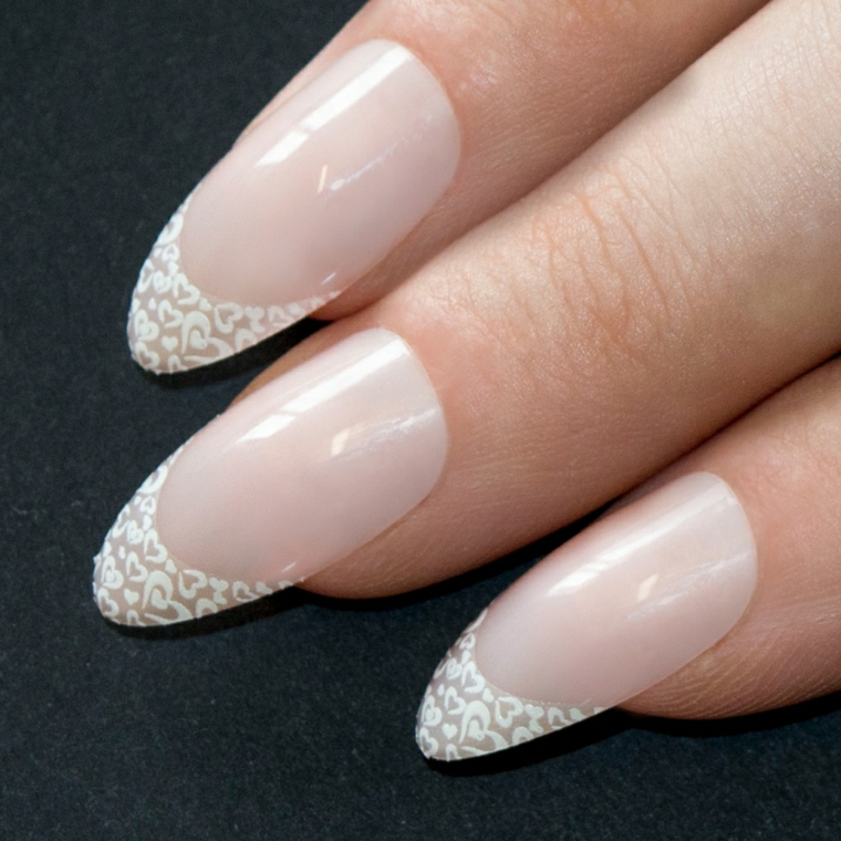 Decorare la french manicure con applicazioni pizzo a forma di cuoricini di colore bianco 