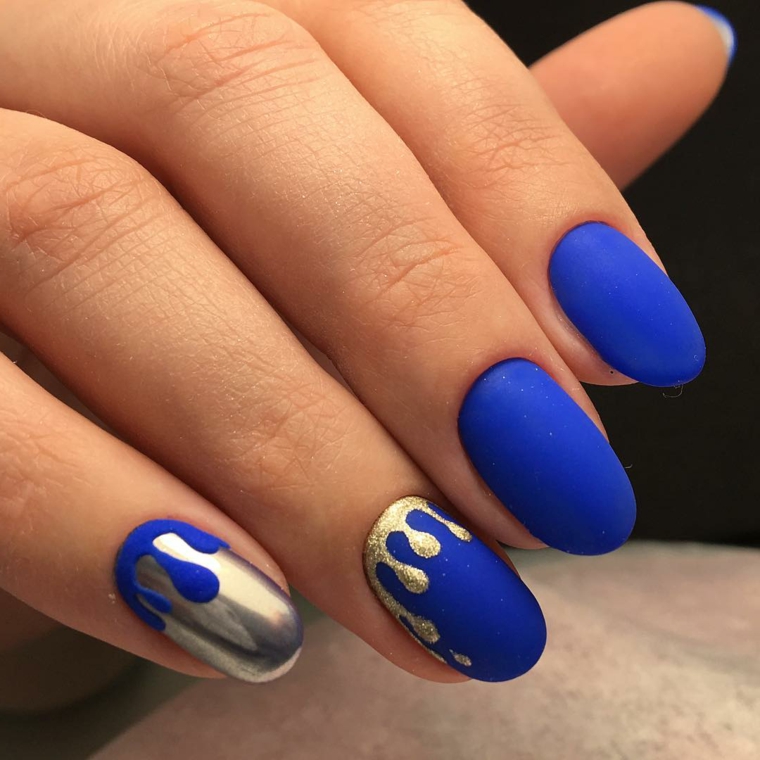 Nail art e decorazione di color oro su una base di smalto blu effetto mat 