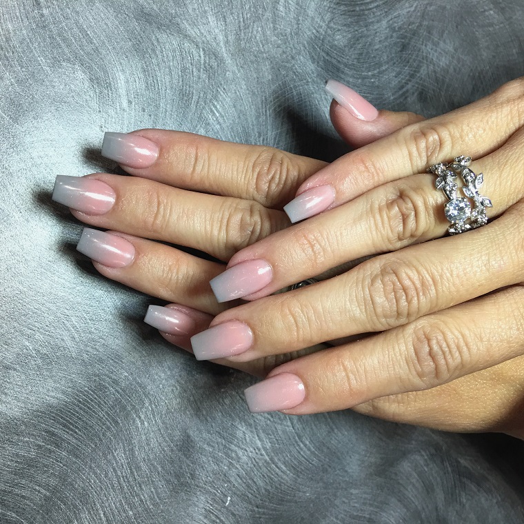 Manicure con unghie lunghe di colore rosa ombè sul grigio con glitter integrati
