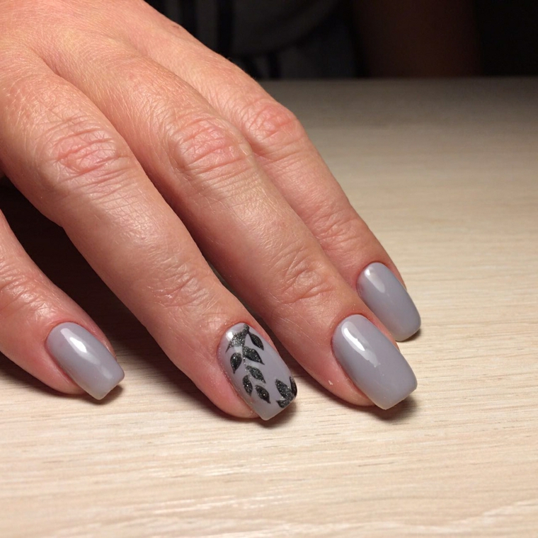 Idea per delle unghie colorate con smalto grigio e decorate con foglie di colore nero 