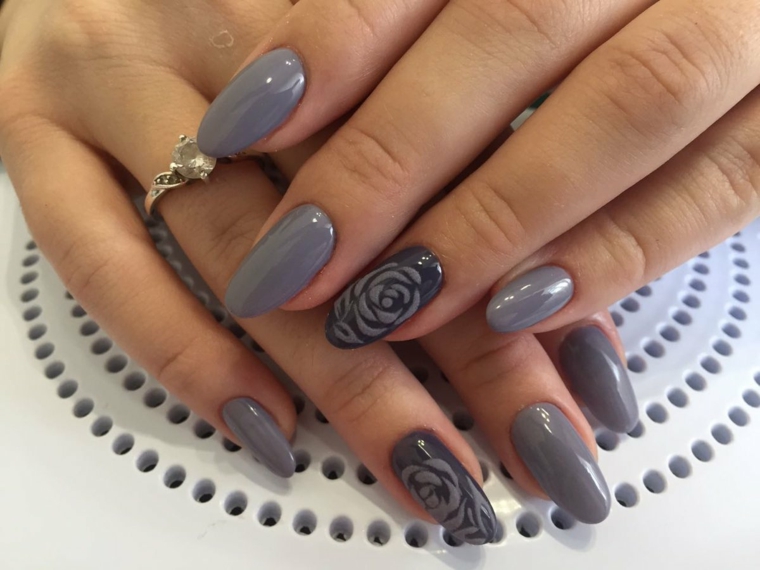 Unghie decorate con un disegno di fiore, smalto di colore grigio per una manicure stiletto