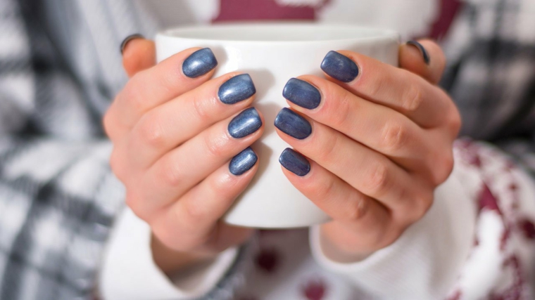tazza nelle mani di una donna unghie con smalto colore blu manicure forma quadrata