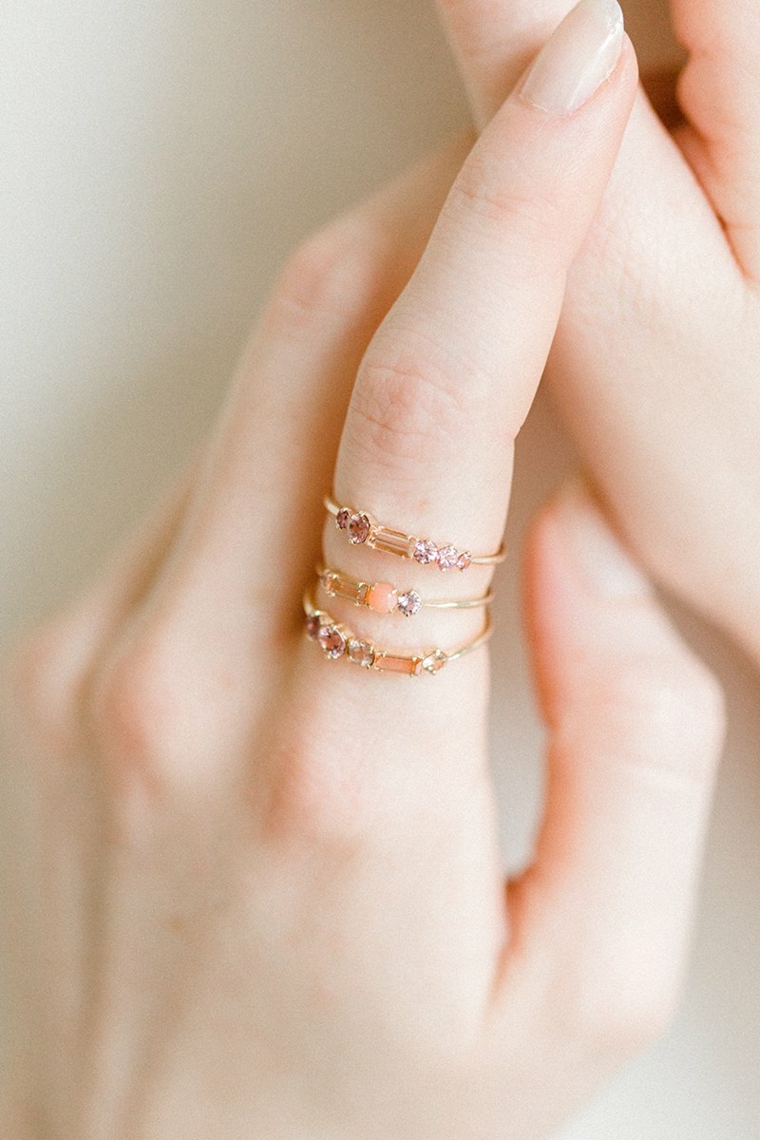 Smalto colore rosa chiaro, anelli in oro, unghie gel semplici, manicure forma arrotondata