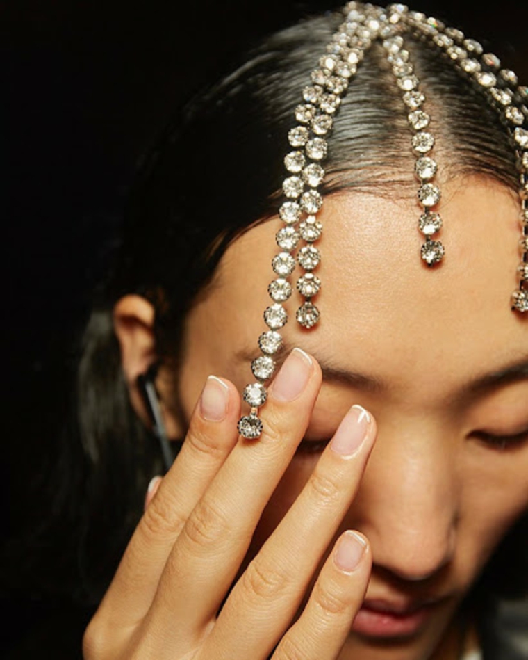 donna con diamanti nei capelli unghie corte squadrata con french manicure