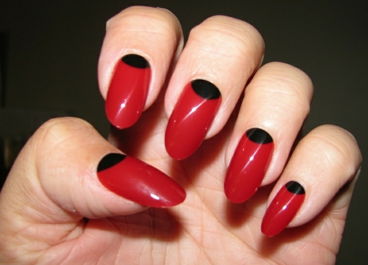 unghie rosso, una manicure originale ma elegante con una decorazione nera ovale