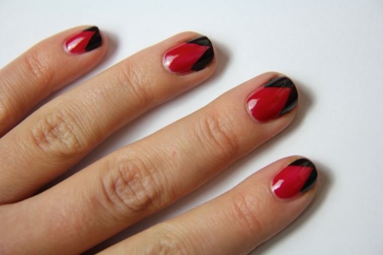unghie rosse con dettagli neri sui bordi in fondo, unghie corte e arrotondate