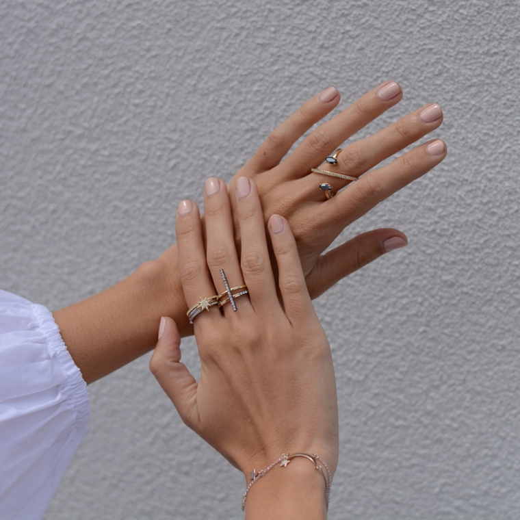 semplice e raffinata manicure con delle unghie neutre corte e squadrate e anelli di tendenza