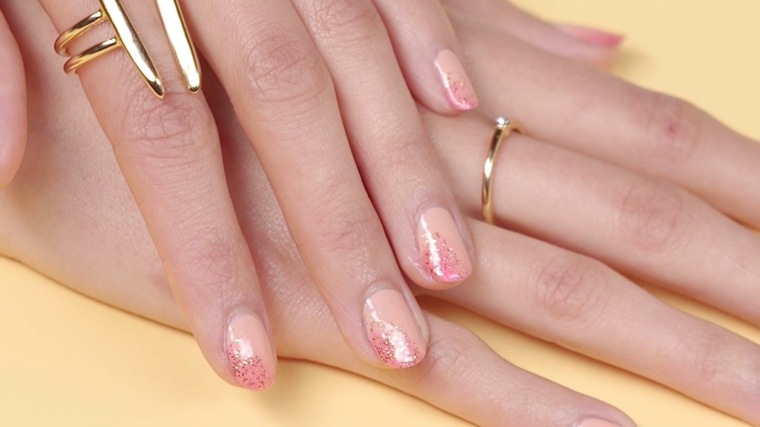 manicure semplice ed elegante con base di smalto nude e brillantini fucsia laterali