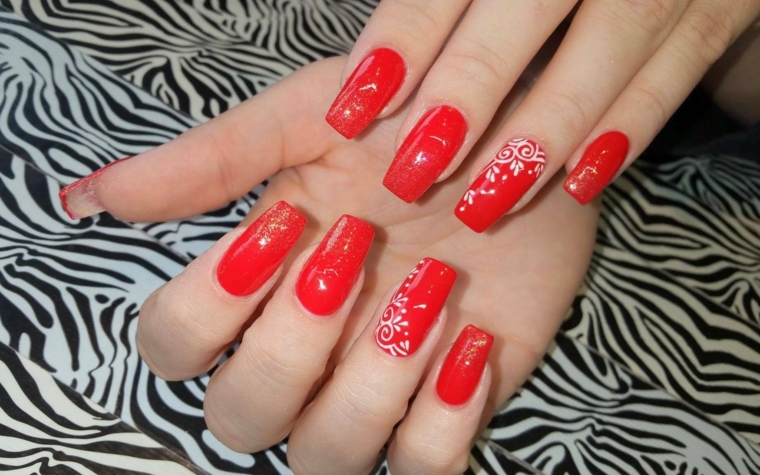 unghie lunghe e squadrate dipinte di rosso e decorate con bianco e oro