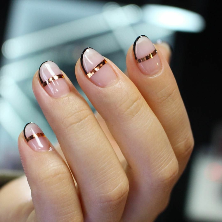 nail art creativa con una striscia dorata nel mezzo, bordo nero e unghie color cipria