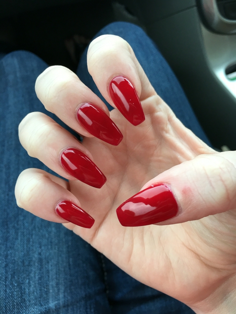 una manicure femminile e sexy realizzata con una tonalità di rosso scura e brillante