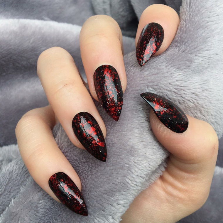 Stiletto con smalto nero, smlto nero effetto marmo rosso, mano di una donna