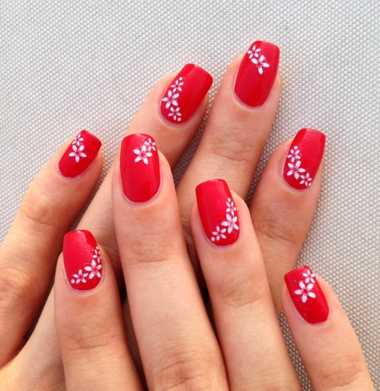nails rosse, una nuance chiara e brillante impreziosita da dei fiori bianchi
