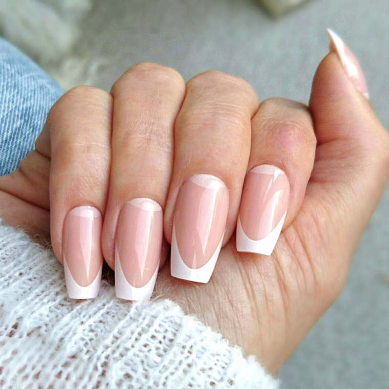 una manicure unghie gel french bianche dalla forma particolare con base rosa carne